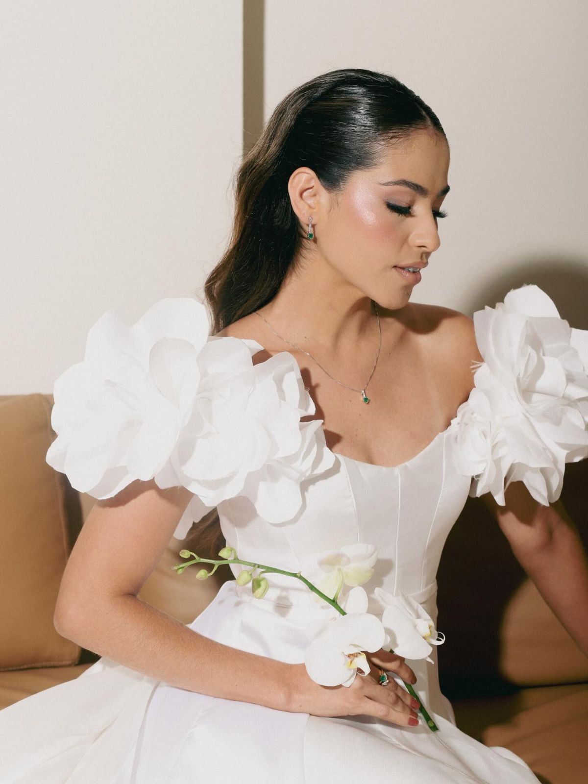 Noiva com mangas de flores esculturais e orquídea